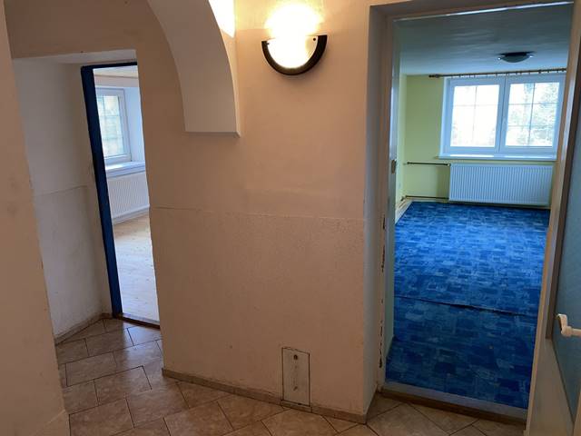 Chodba v přízemí. Omítky zde vyžadují rekonstrukci. Dva pokoje jsou zde zrekonstruované.