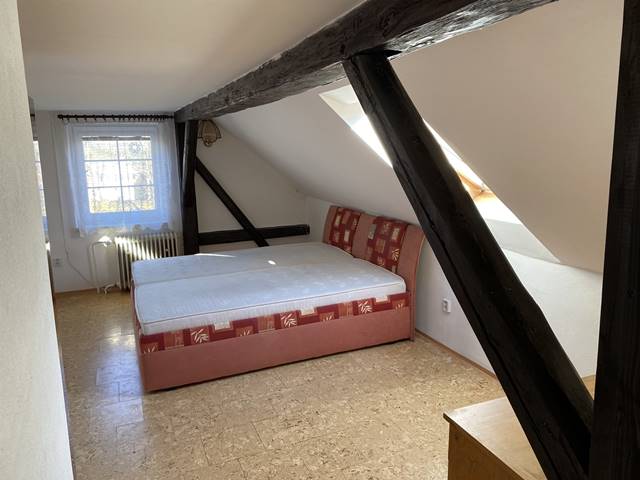Ložnice v podkroví orientovaná na severovýchod. Střešní okno je opatřeno roletou se 100% nepropustností světla.